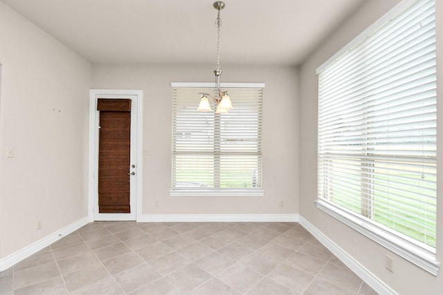 unfurnished dining area with light tile patterned floors and a notable chandelier