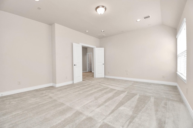 unfurnished room with light carpet and lofted ceiling