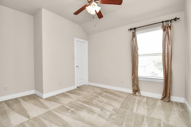 carpeted spare room featuring vaulted ceiling and ceiling fan