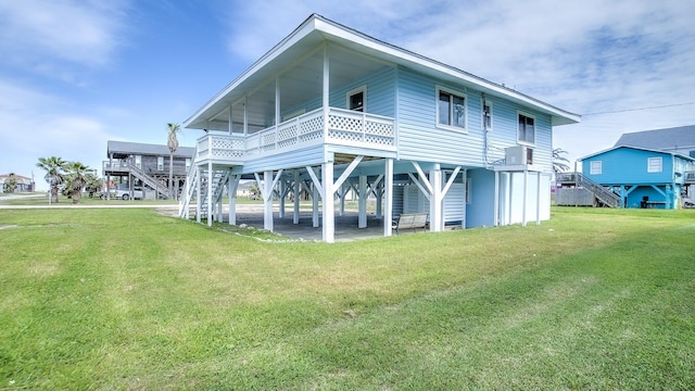 back of house featuring a lawn and stairway