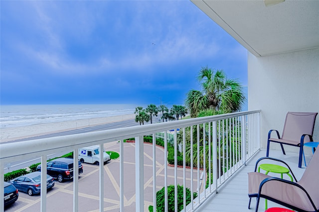 balcony featuring a beach view and a water view