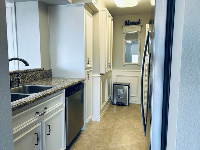 kitchen featuring light tile patterned floors, dark stone countertops, white cabinetry, and dishwasher