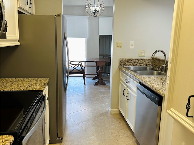 kitchen featuring stainless steel dishwasher, hanging light fixtures, white cabinets, light tile patterned floors, and sink