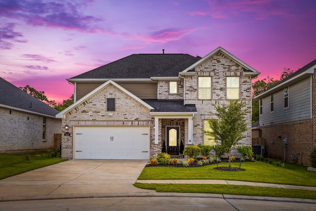 view of front of house with a garage, central AC, and a yard