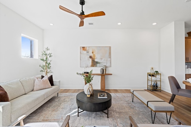 living room with ceiling fan and light wood-type flooring