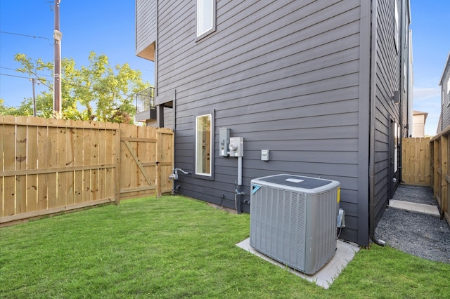 view of home's exterior with cooling unit and a yard