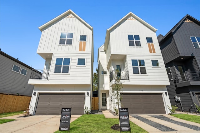 view of front of house featuring board and batten siding, an attached garage, and fence