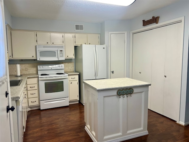 kitchen with a center island, dark hardwood / wood-style flooring, white appliances, tasteful backsplash, and cream cabinetry