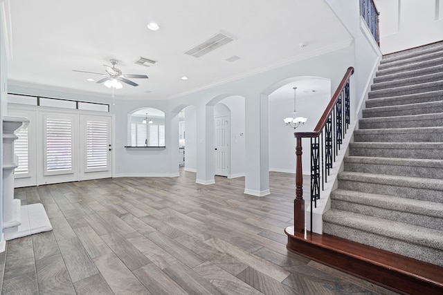 entryway featuring ceiling fan with notable chandelier, crown molding, and hardwood / wood-style floors