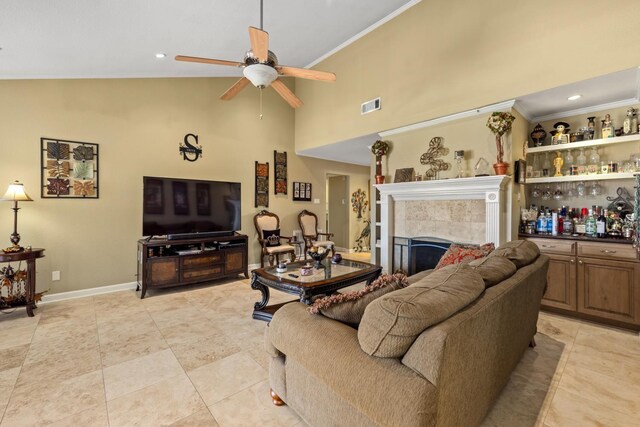 tiled living room featuring ceiling fan, high vaulted ceiling, and a tiled fireplace