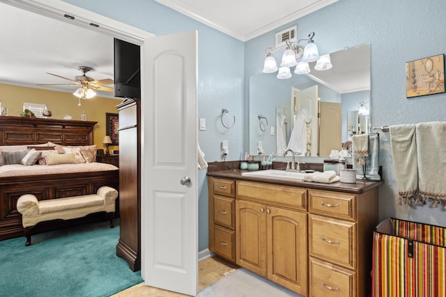 bathroom featuring ceiling fan, crown molding, and vanity