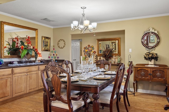 dining room featuring an inviting chandelier, light hardwood / wood-style flooring, and ornamental molding