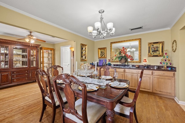 dining area with ceiling fan with notable chandelier, crown molding, and light hardwood / wood-style floors