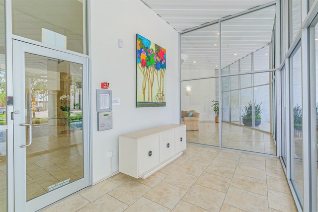 interior space with light tile patterned floors, a towering ceiling, and expansive windows