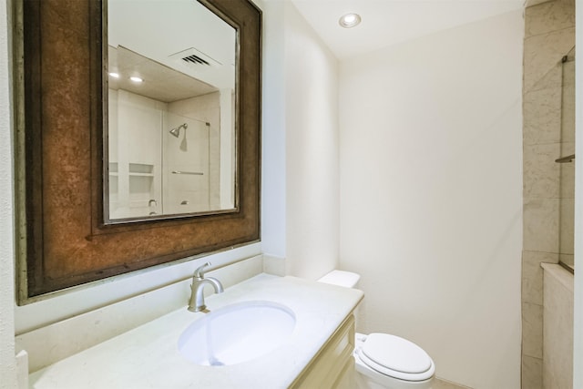 bathroom with vanity, toilet, and a shower