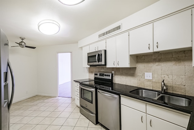 kitchen featuring ceiling fan, backsplash, white cabinets, sink, and stainless steel appliances