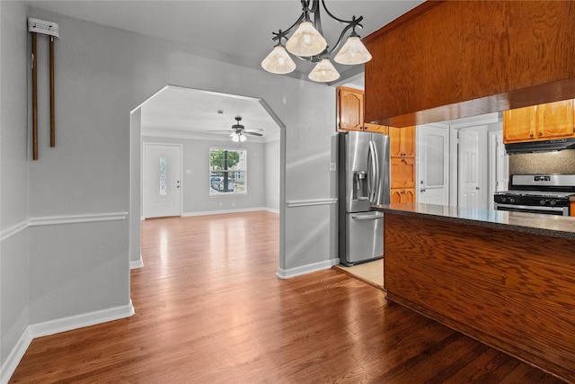 kitchen featuring ceiling fan, appliances with stainless steel finishes, hanging light fixtures, and light hardwood / wood-style flooring