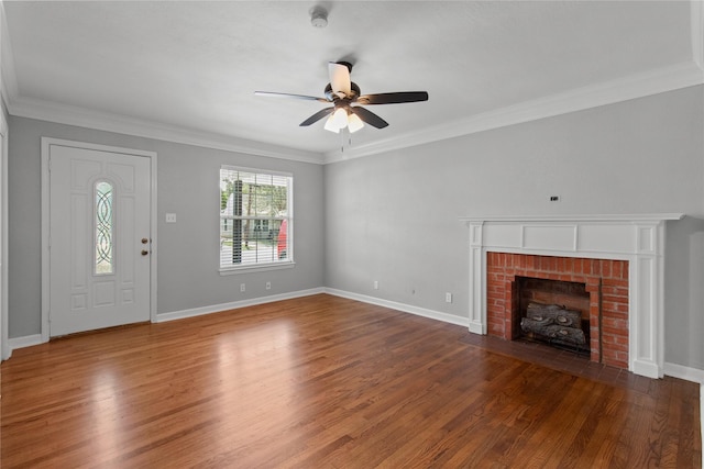 unfurnished living room with ornamental molding, a brick fireplace, and dark hardwood / wood-style flooring