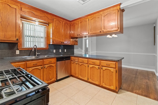 kitchen with sink, range with gas cooktop, stainless steel dishwasher, kitchen peninsula, and backsplash