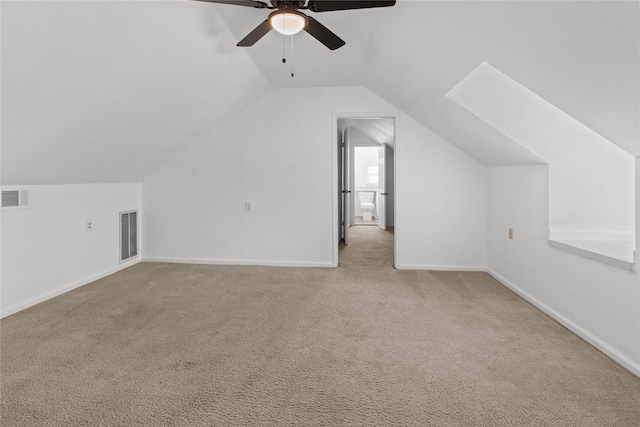 bonus room with lofted ceiling with skylight, light colored carpet, and ceiling fan