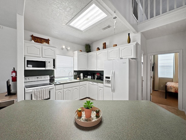 kitchen with white cabinets, a textured ceiling, sink, and white appliances