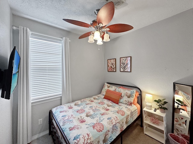 bedroom featuring ceiling fan, carpet, and a textured ceiling