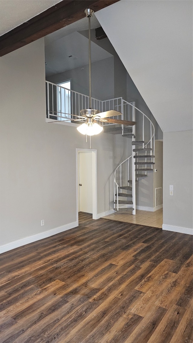 interior space with ceiling fan, hardwood / wood-style floors, and a high ceiling