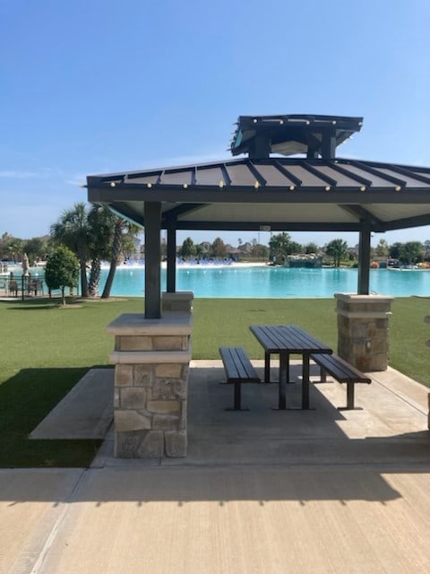 surrounding community with a gazebo, a yard, and a water view