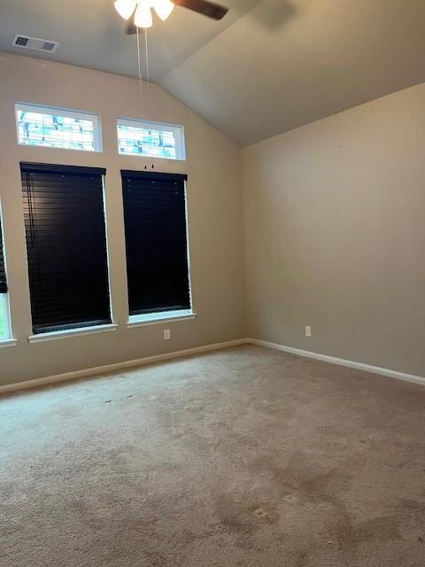 spare room featuring carpet, vaulted ceiling, and ceiling fan