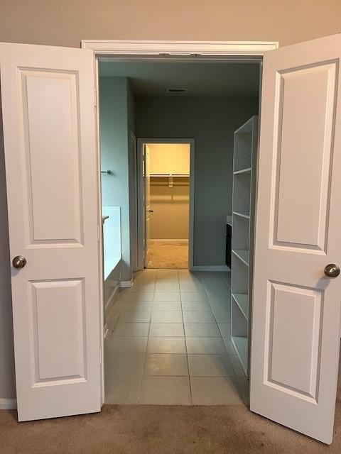 hallway with tile patterned flooring