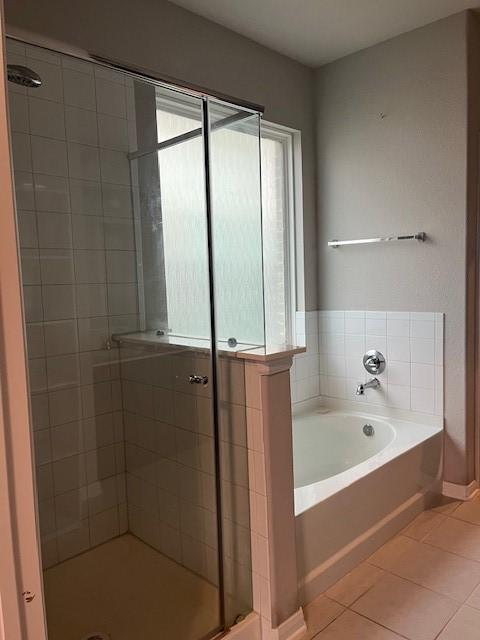 bathroom with tile patterned floors and independent shower and bath