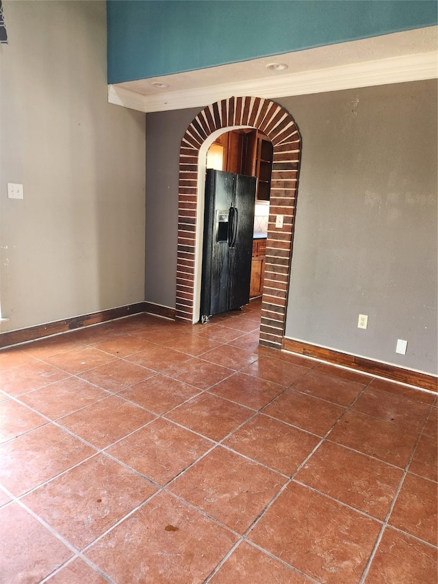 spare room with dark tile patterned floors and baseboards