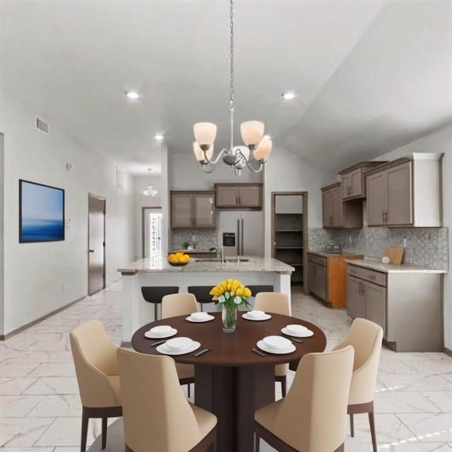 dining space featuring a chandelier and vaulted ceiling