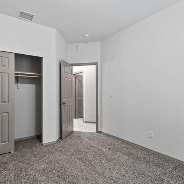 unfurnished bedroom with carpet floors and a closet