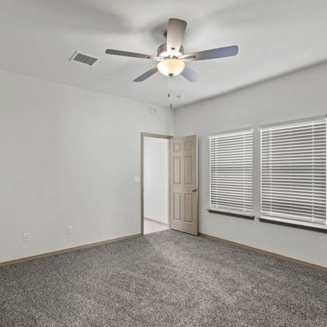 carpeted spare room with ceiling fan