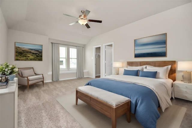 carpeted bedroom featuring lofted ceiling, ceiling fan, a spacious closet, and baseboards