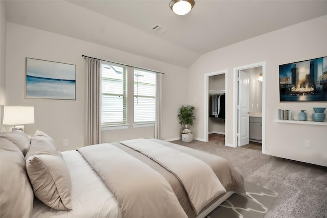 bedroom with baseboards, visible vents, a spacious closet, vaulted ceiling, and carpet floors