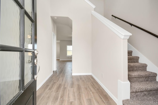 interior space with wood tiled floor, baseboards, and stairs