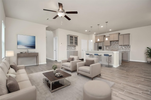 living area featuring ceiling fan, light wood-style flooring, recessed lighting, visible vents, and baseboards