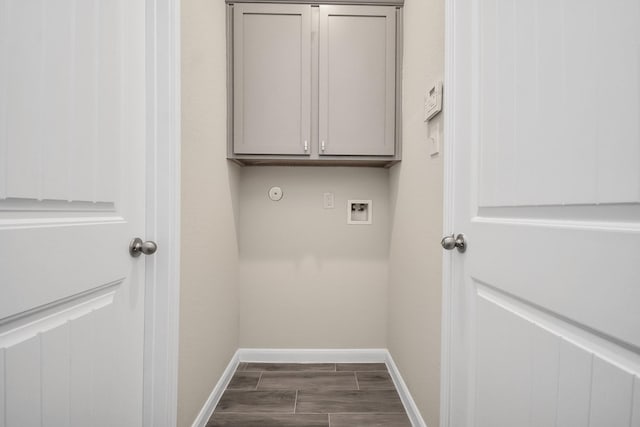 laundry room featuring hookup for a washing machine, baseboards, dark wood finished floors, and cabinet space