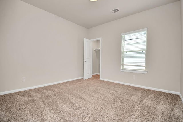 carpeted spare room with visible vents and baseboards