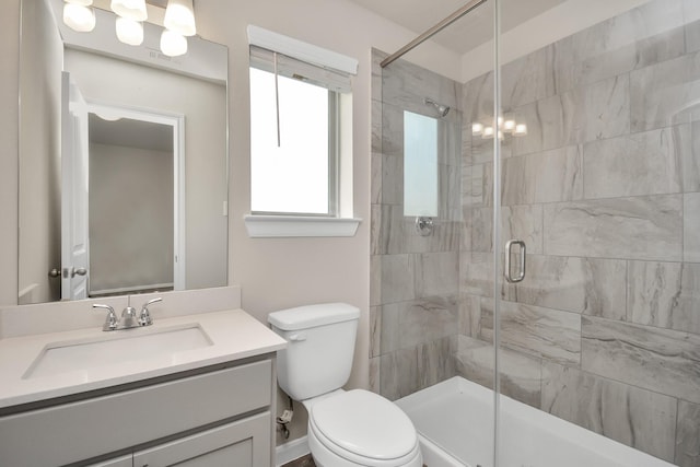 bathroom featuring toilet, a stall shower, and vanity