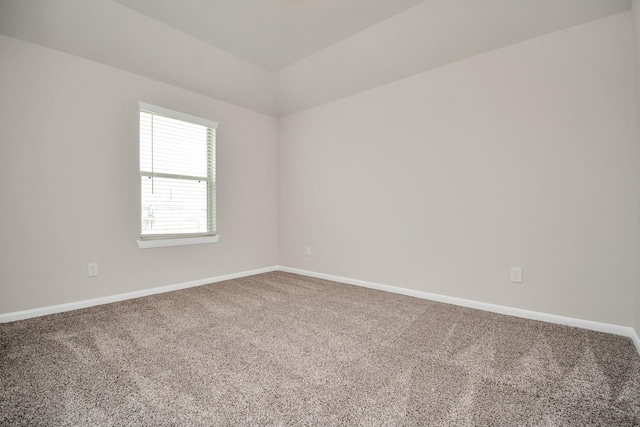 carpeted spare room featuring baseboards