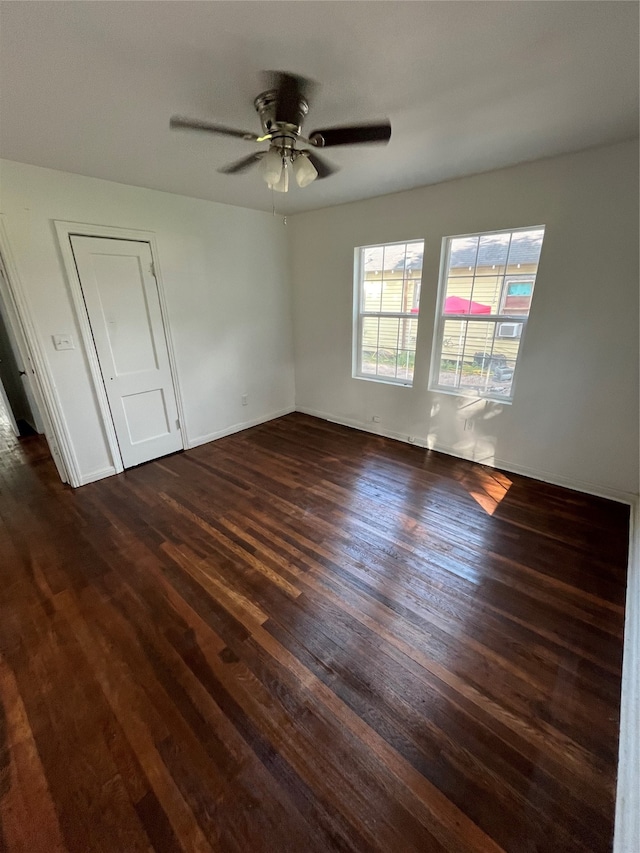 spare room with dark hardwood / wood-style flooring and ceiling fan