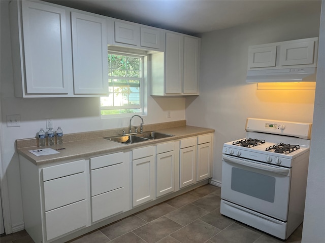 kitchen featuring tile patterned floors, sink, white gas stove, and white cabinetry