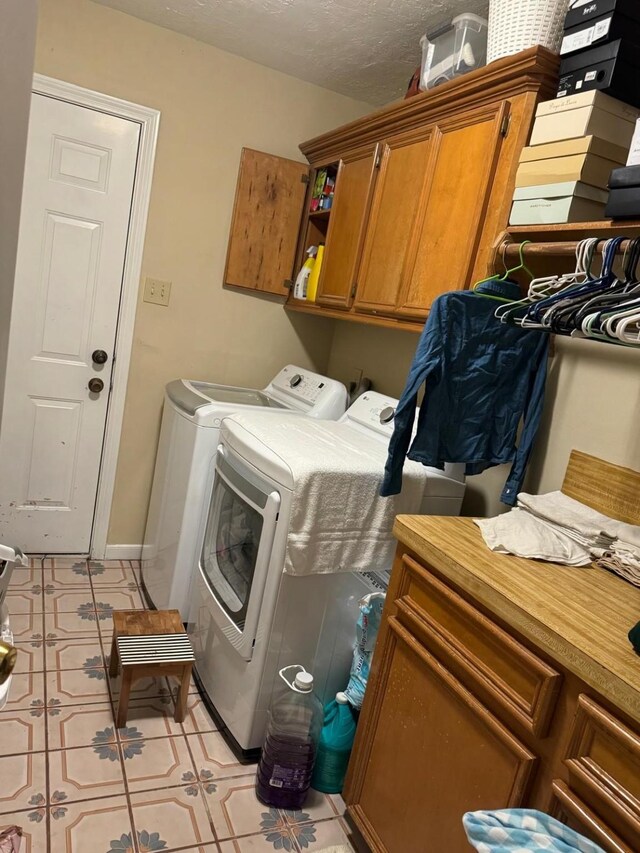 washroom with cabinets, independent washer and dryer, and light tile patterned floors