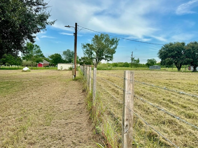 view of yard with a rural view and an outbuilding