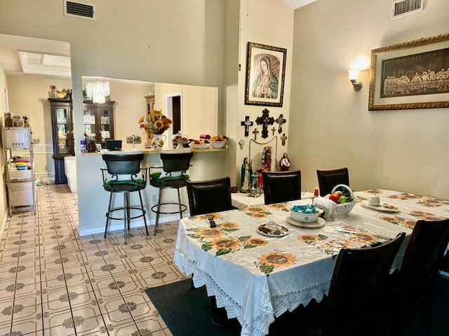 dining area with a high ceiling and light tile patterned floors