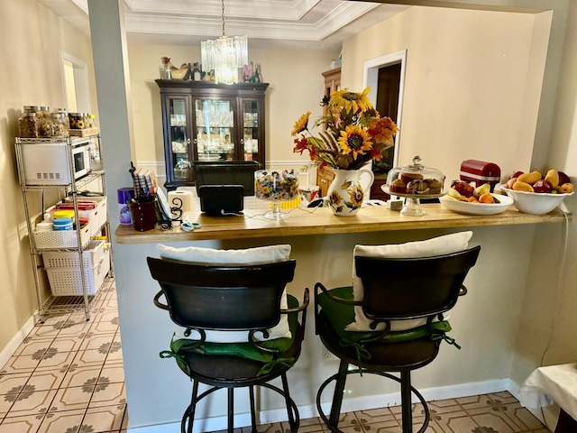 bar featuring pendant lighting, light tile patterned flooring, ornamental molding, and a chandelier