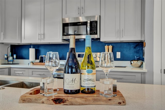 kitchen with light stone counters, white cabinetry, and tasteful backsplash